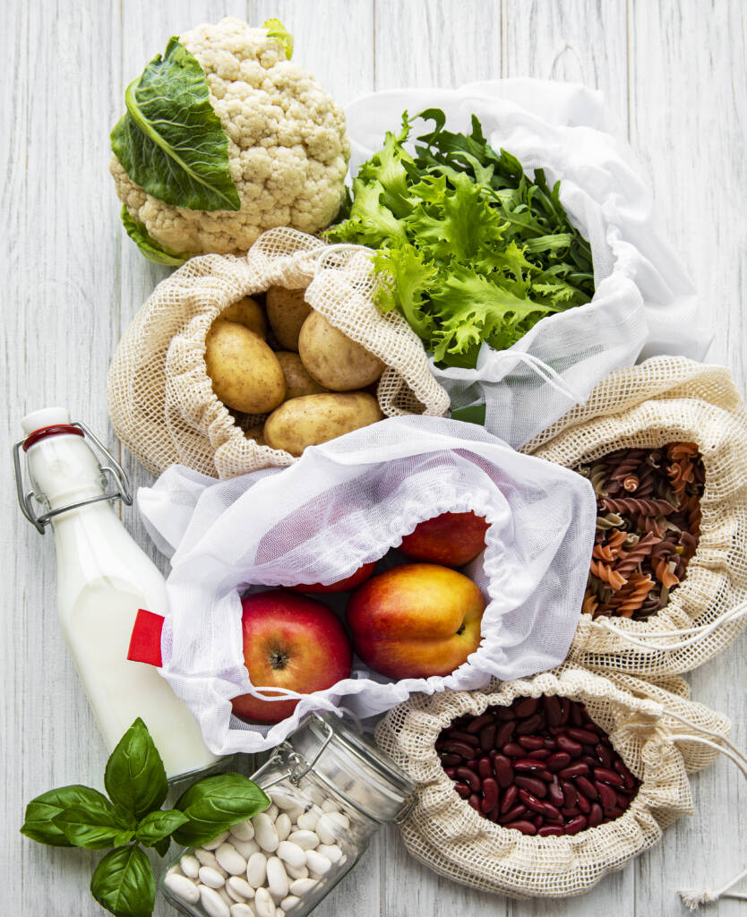 Frisches Gemüse und Früchte in Stoffsäcken auf dem Tisch